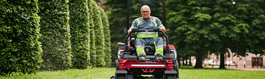 Werknemer op grasmaaier in zomerse omstandigheden met ademende werkkleding voor comfort, veiligheid en UV-bescherming.